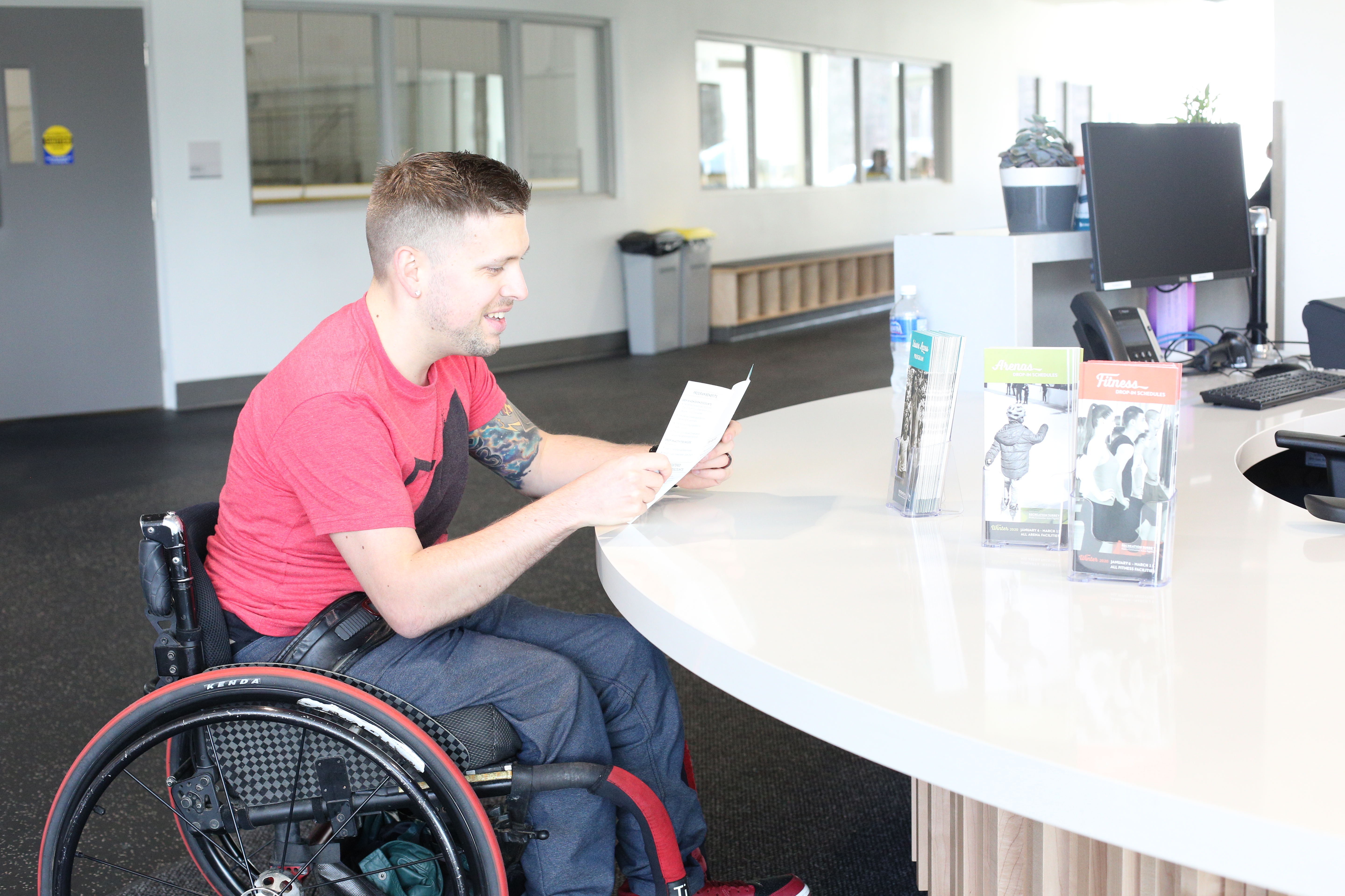 Wheelchair user Marco at universal height reception counter 