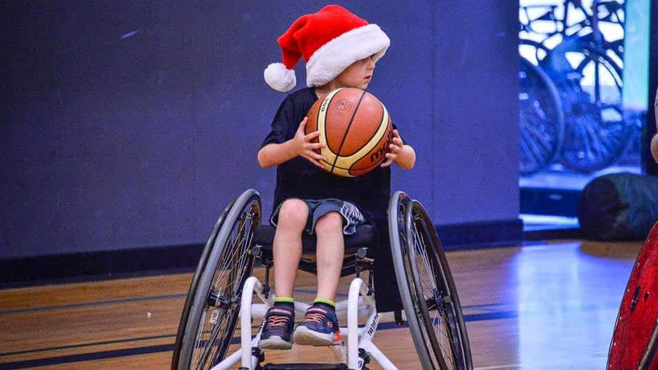 Brody playing wheelchair basketball