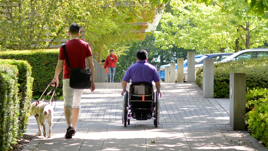 Two people with disabilities on an accessible path.