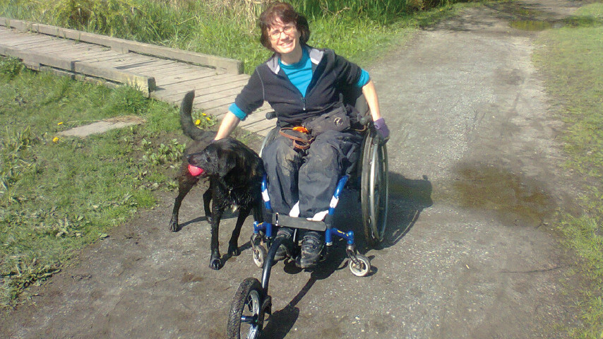 Luisa with her new FreeWheel attachment and a happy dog friend.