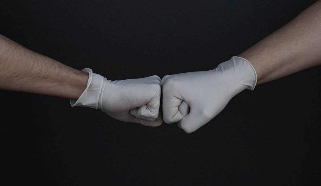 two fists wearing medical gloves