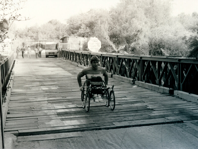 Rick Hansen traverse à fauteuil roulant le pont Allenby en Jordanie.