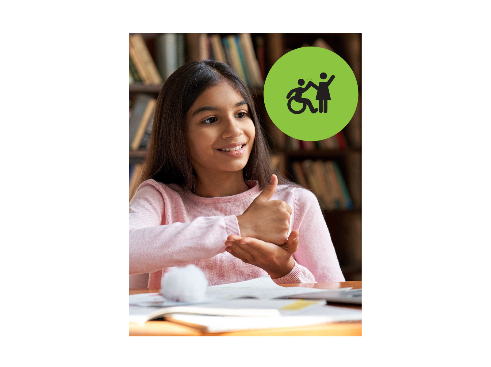 Teenage girl looking off camera, using sign langauge. Small green circle icon with graphic of person in a wheelchair high-fiving a person that is standing.