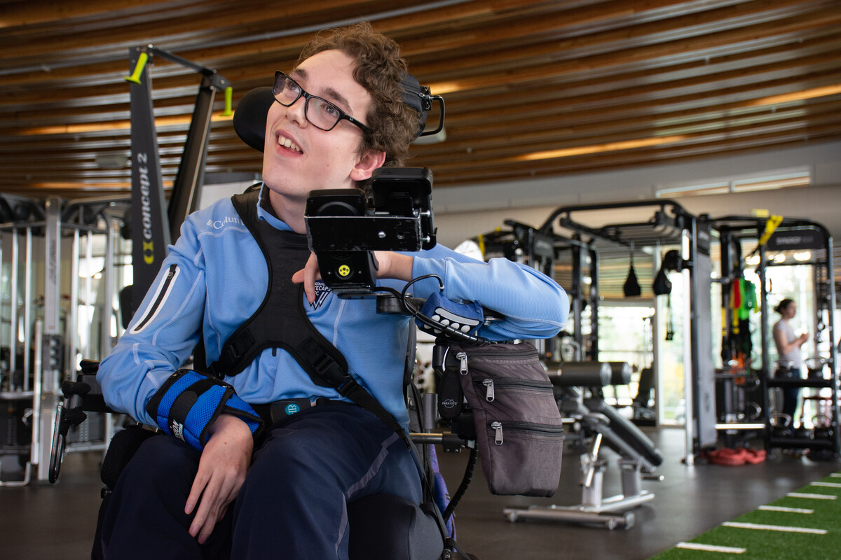 A man uses a wheelchair to navigate a gym