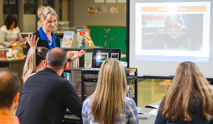 Educator explains to group of people what she does. 