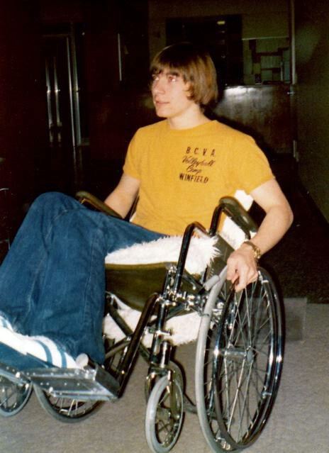 A teenage Rick Hansen popping a wheelie in his wheelchair.