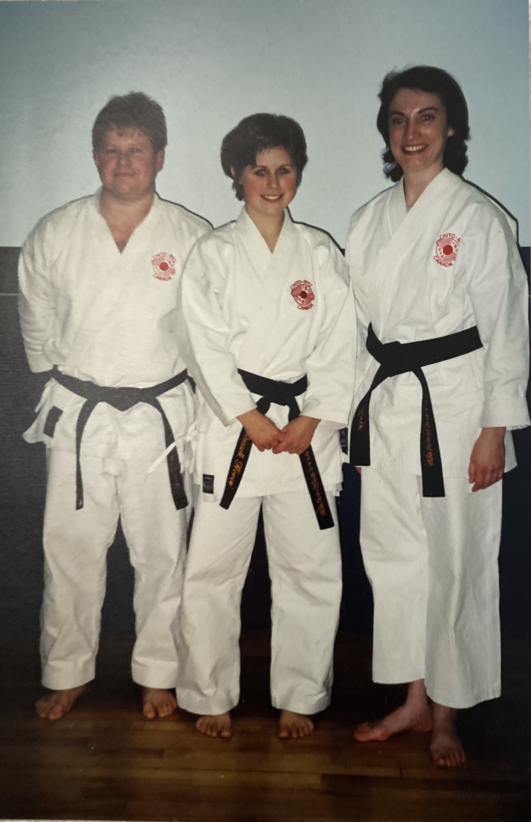 three people in athletic white jumpsuits with belts