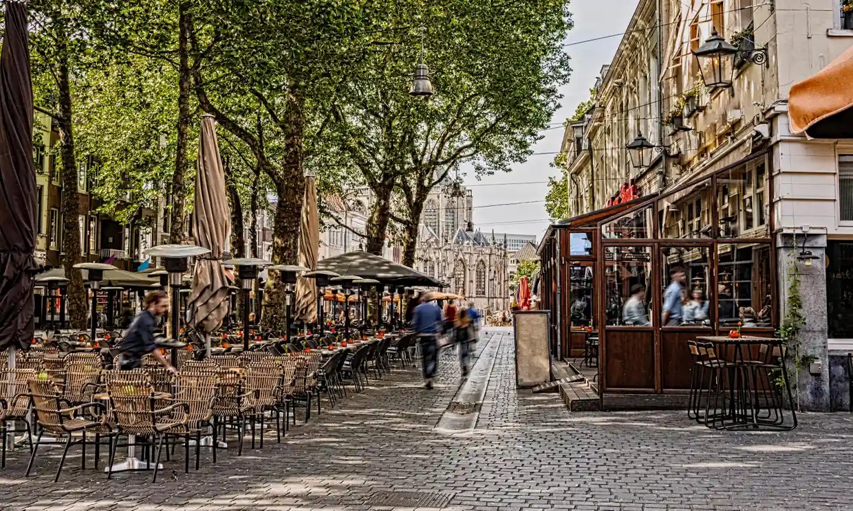 cobblestone street outside a cafe with flipped cobblestones on a sunny day with people in blurred motion