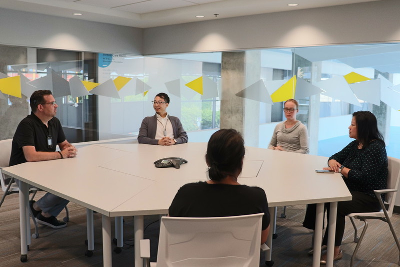 Wavefront CEO Christopher T. Sutton seated with a team of employees around a meeting table.