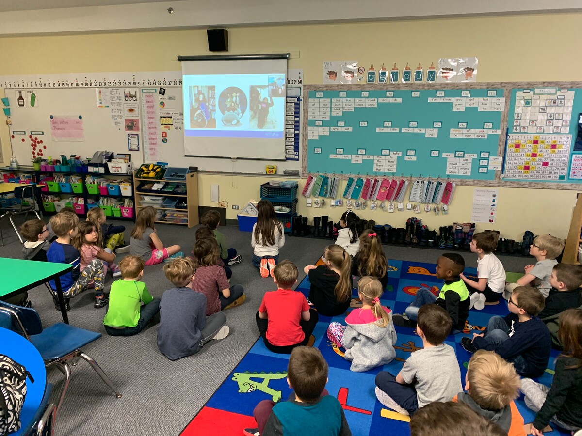 Group of students in a classroom who are viewing an Ambassador presentation from a projector.