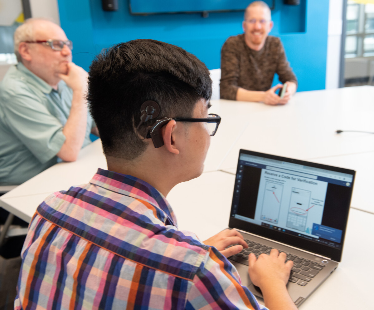 A person uses a cochlear implant to listen while in a meeting