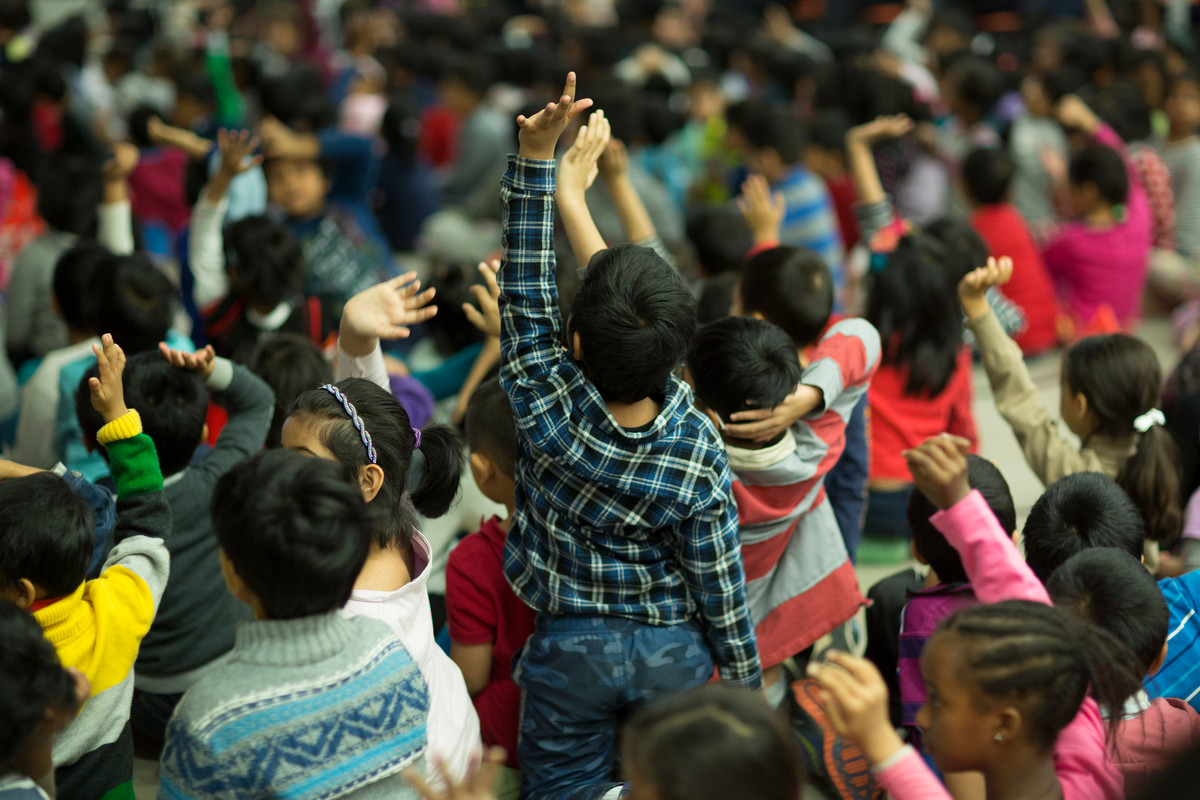 students with hands up