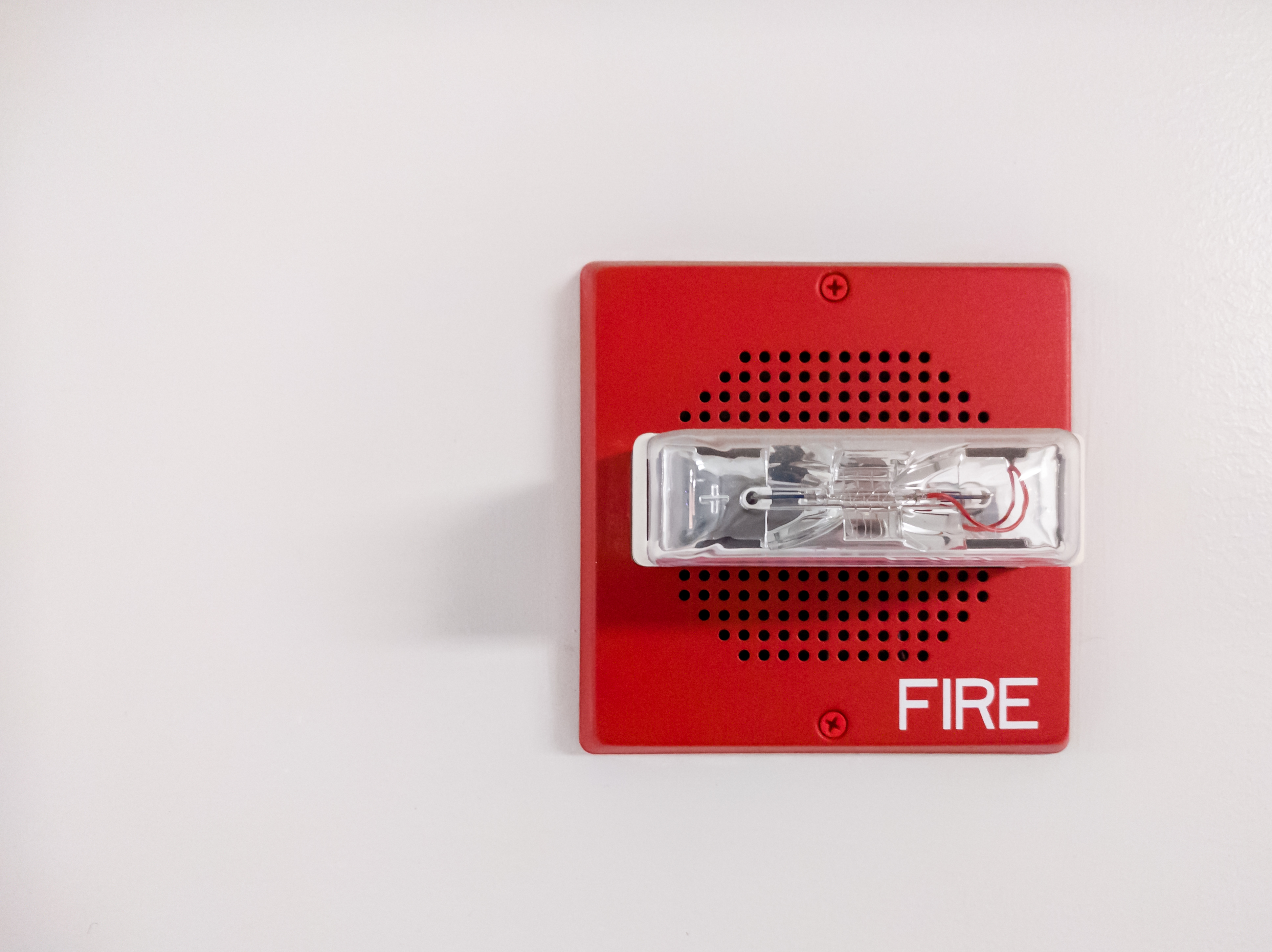 Red fire alarm on grey wall 