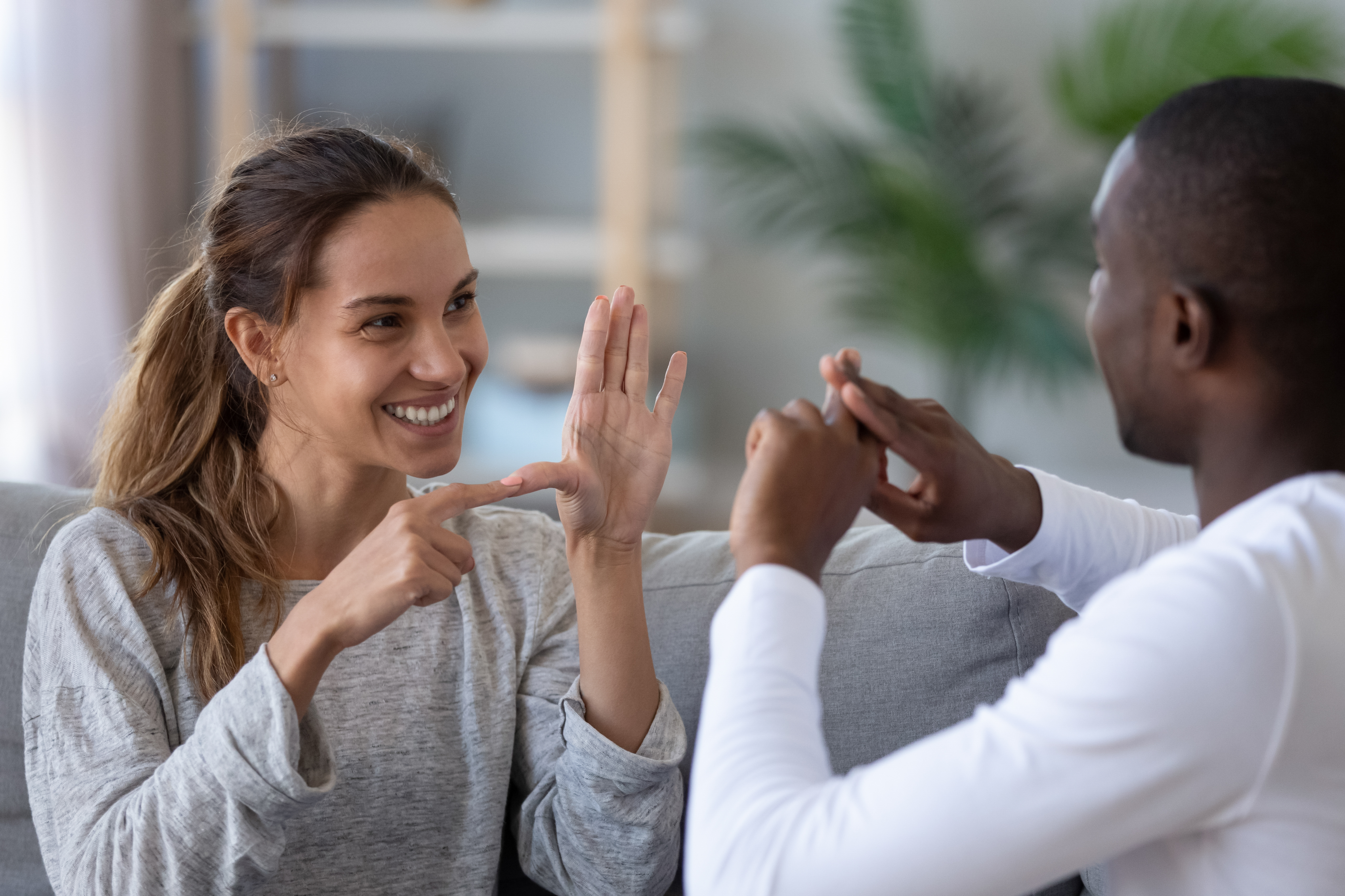 Two people facing each other and communicating in sign language