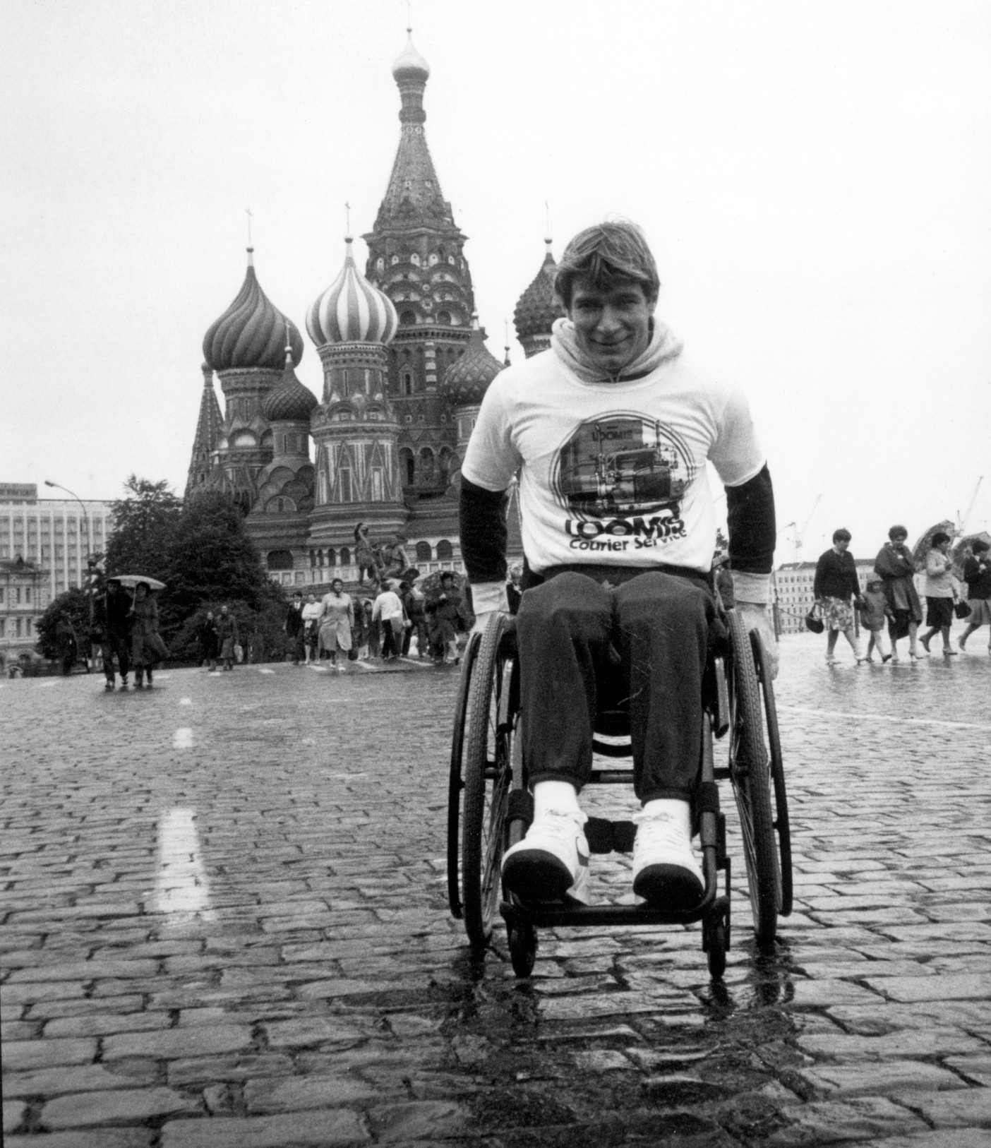 A man (Rick) in a wheelchair facing the camera. In the background, the iconic onion domes of Saint Basil's Cathedral in Moscow 