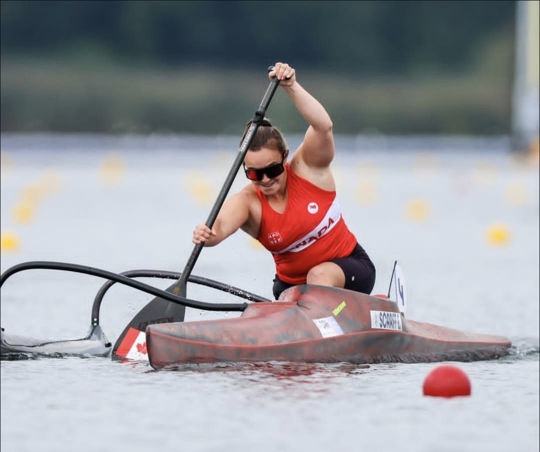 A woman para‑canoe athlete paddles powerfully across open water4