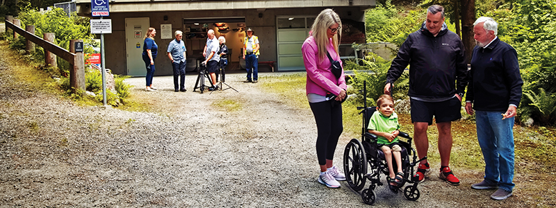 A group of people at Mossom Creek Hatchery. There is a young person using a wheelchair.