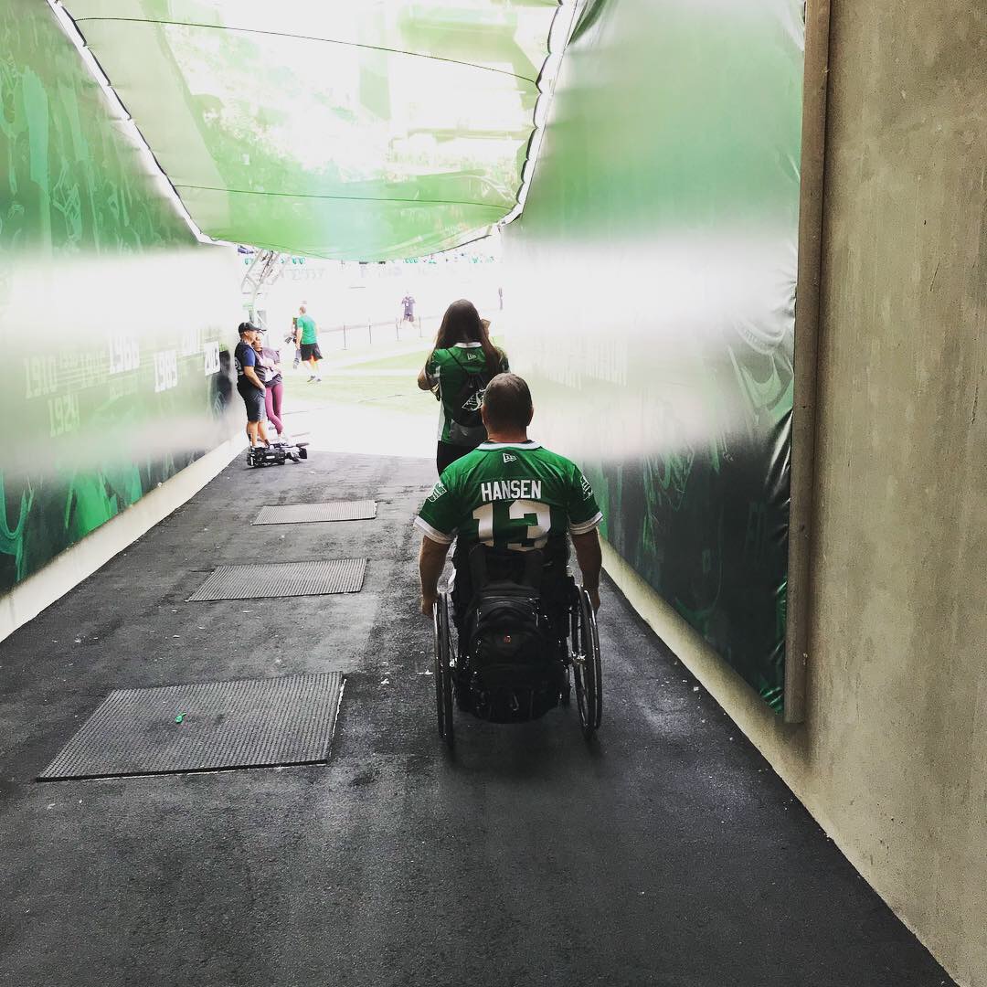 Rick Hansen wheels through tunnel at Roughriders game