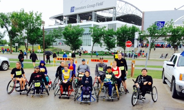 Group of young wheelchair athletes outdoors wearing race gear