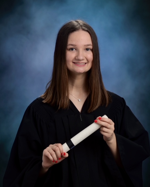 Girl with brown hair in graduation photo holding scroll