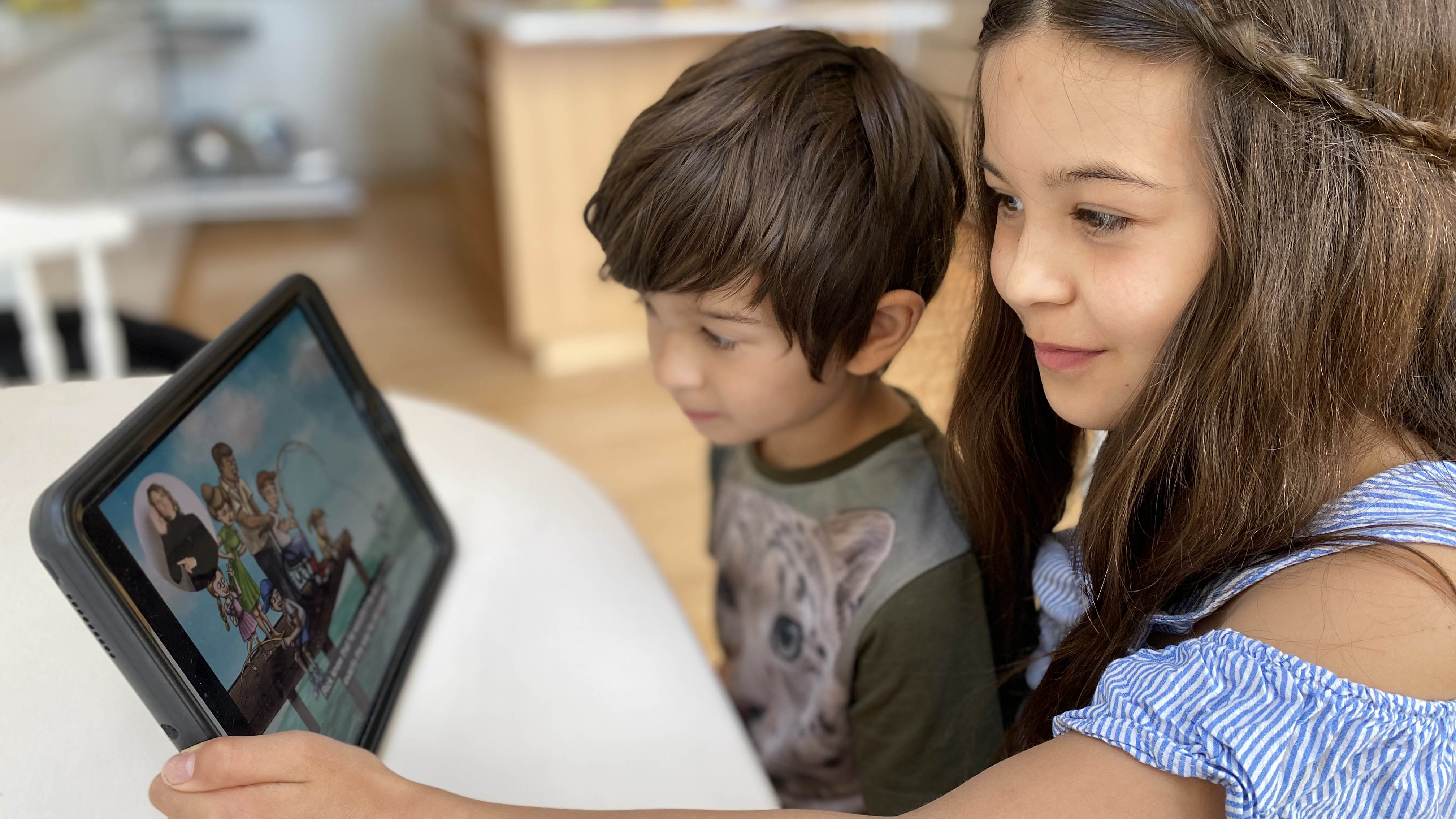 two children watch video smiling