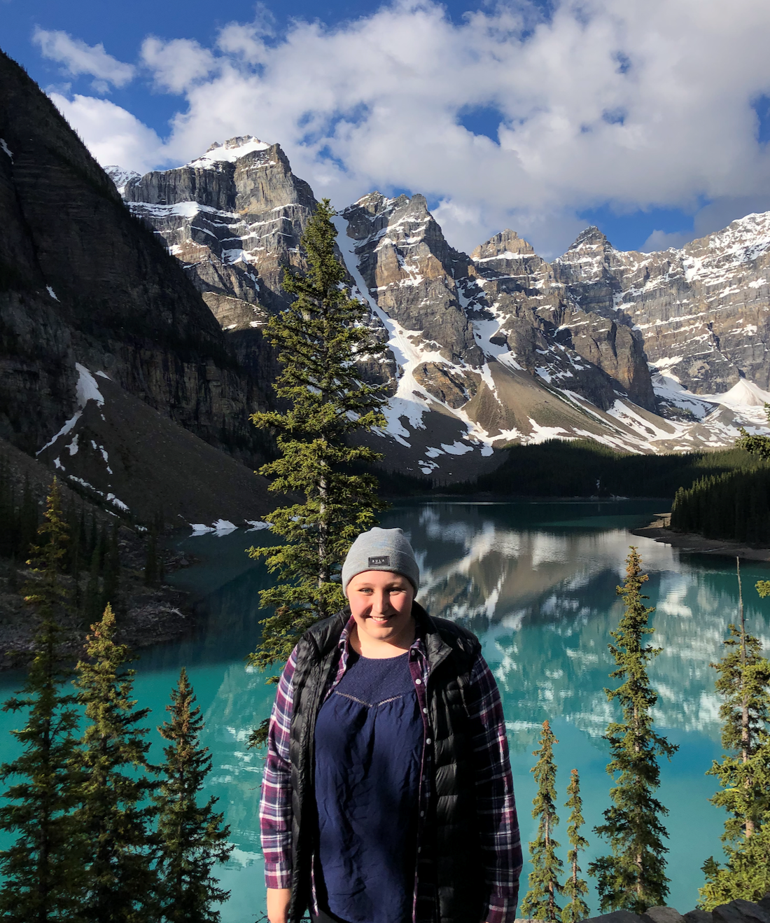 Girl outside in front of a mountain lake