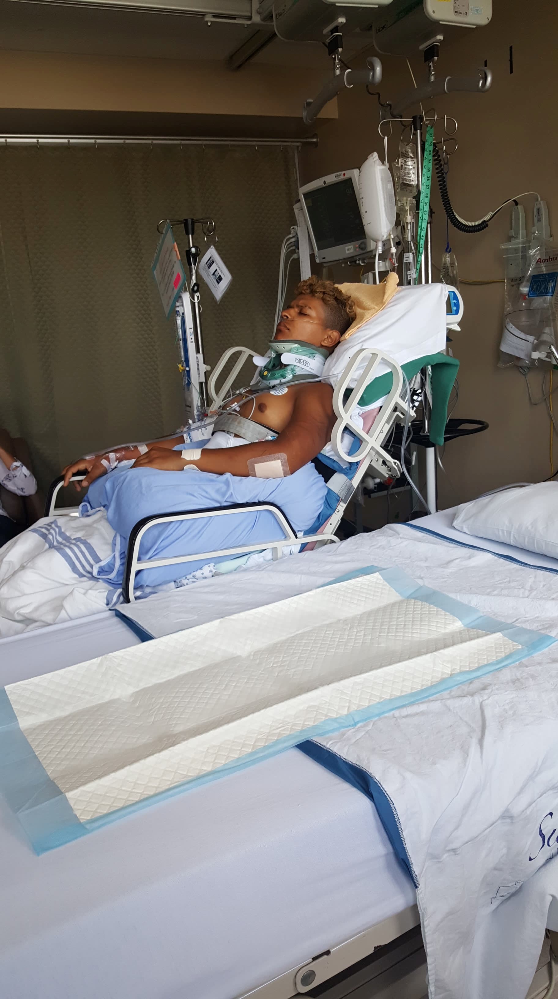 Paulo in laying hospital bed after his accident.