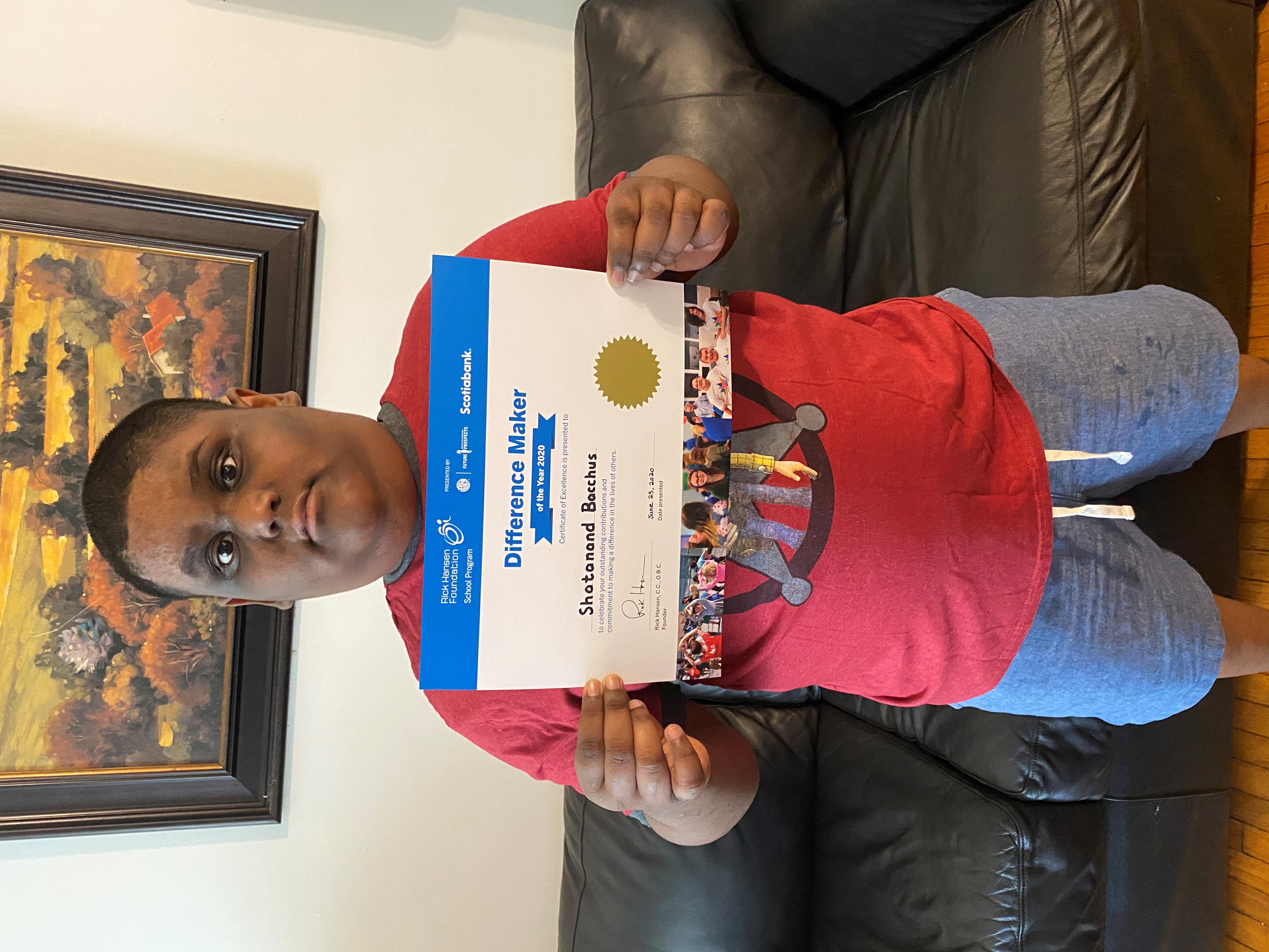 Young boy holds his certificate. 