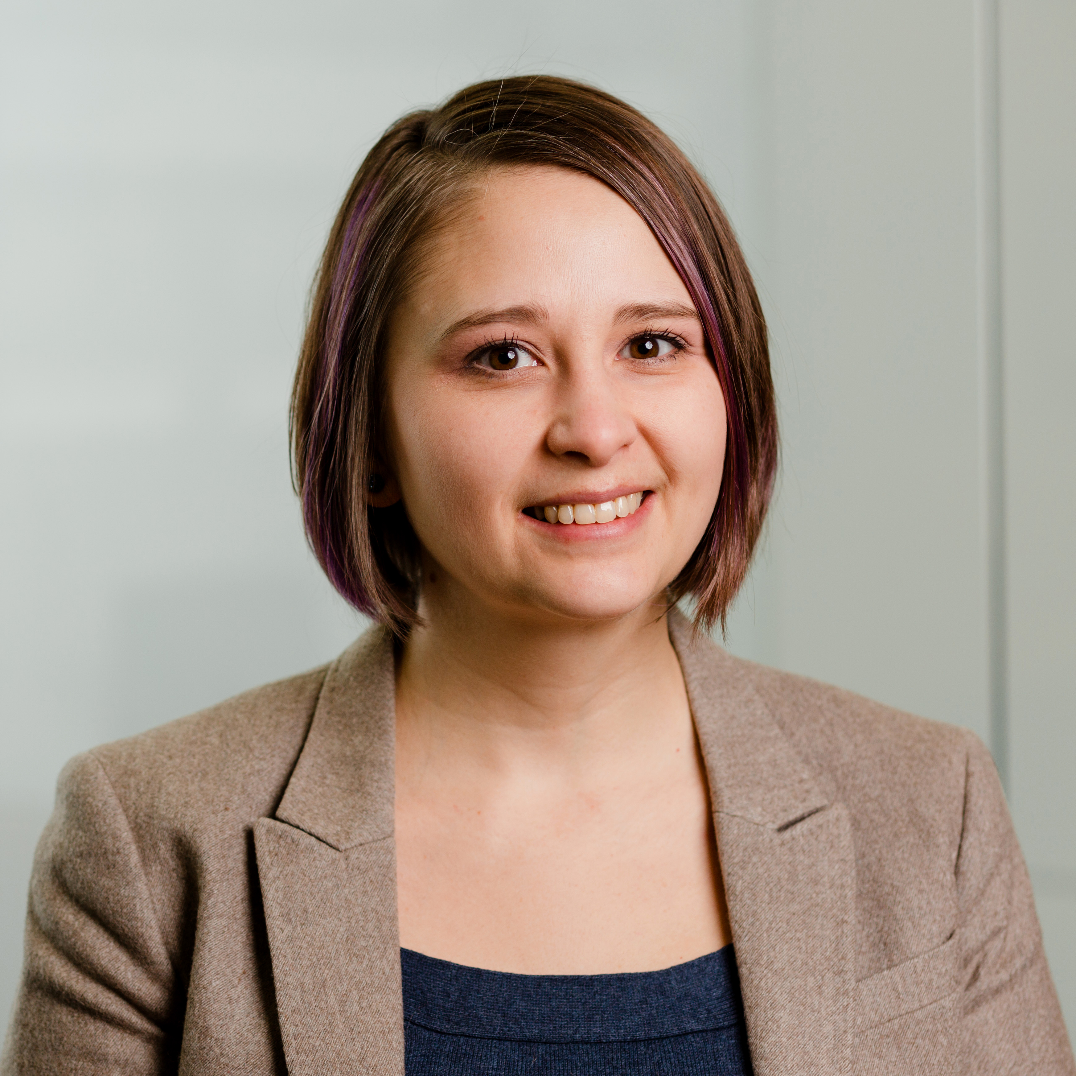 Sherry Hastinga, who has chin-length brown hair and brown eyes. She is wearing a beige blazer and standing in front of a cream-coloured wall.