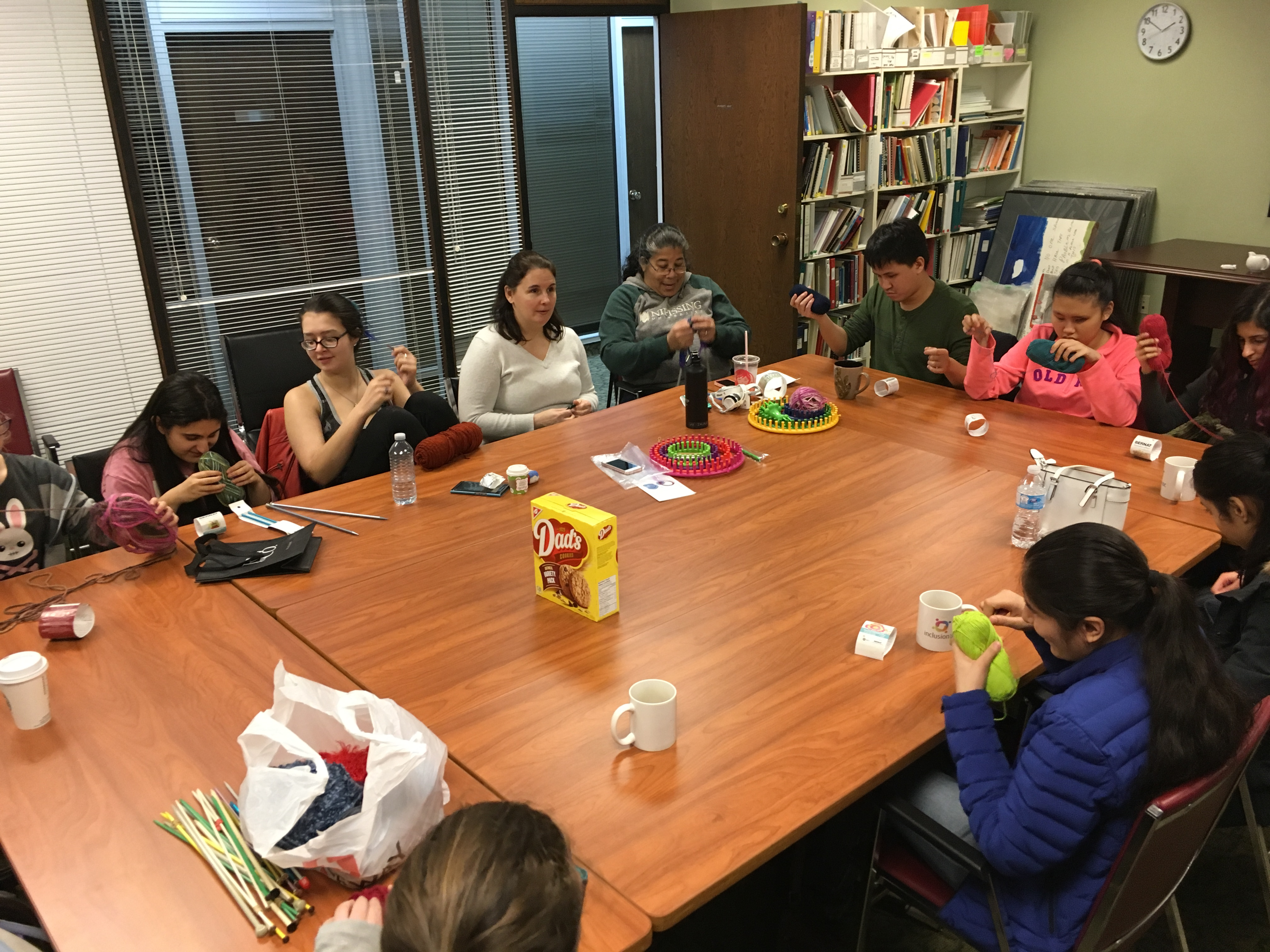 Photo of people seated around a large table all crafting bunnies together.