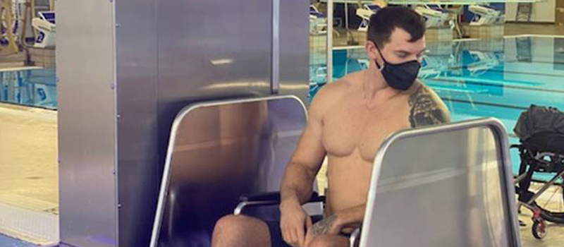 man in wheelchair and bathing suit uses pool lift