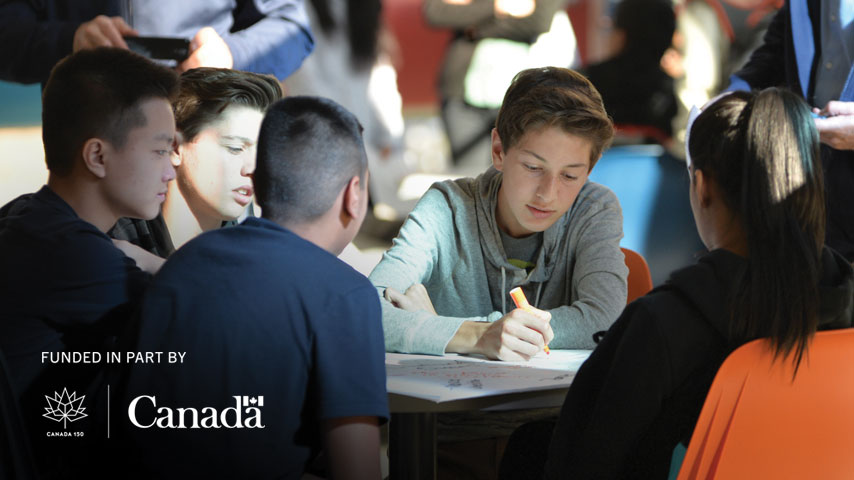 Students discussing group project, funded in part by the Canadian government.