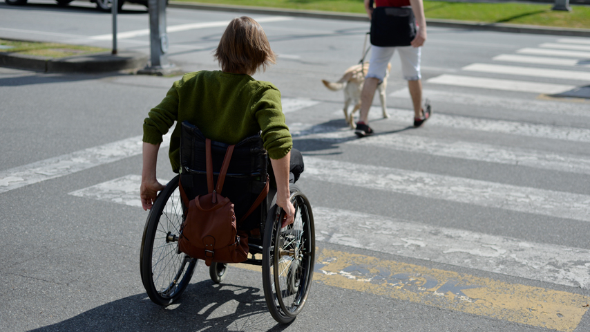 Woman in wheelchair crossing the road