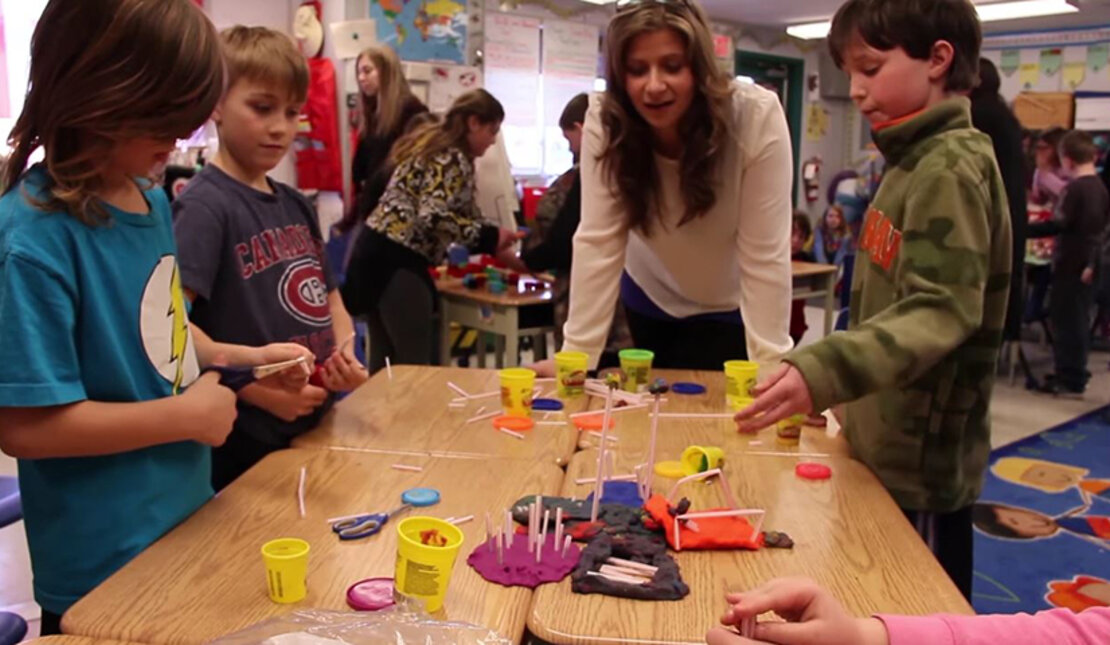 Students gather as they participate in a play-doh activity