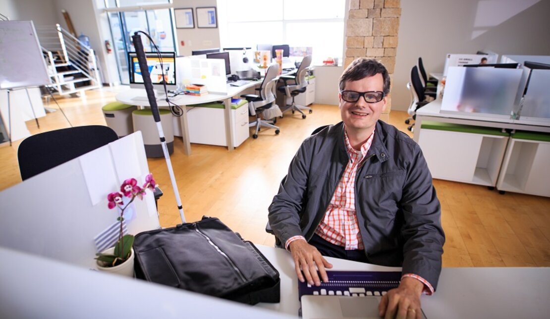 Martin Courcelles at his accessible desk and office space 