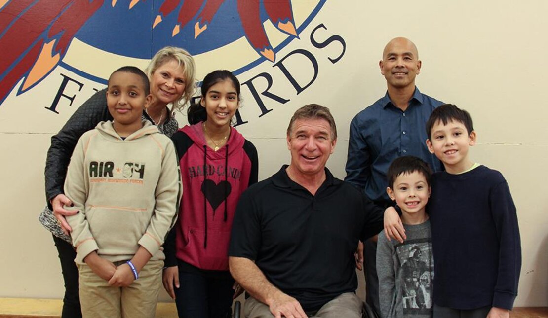 Rick poses with students after presentation about people with disabilities