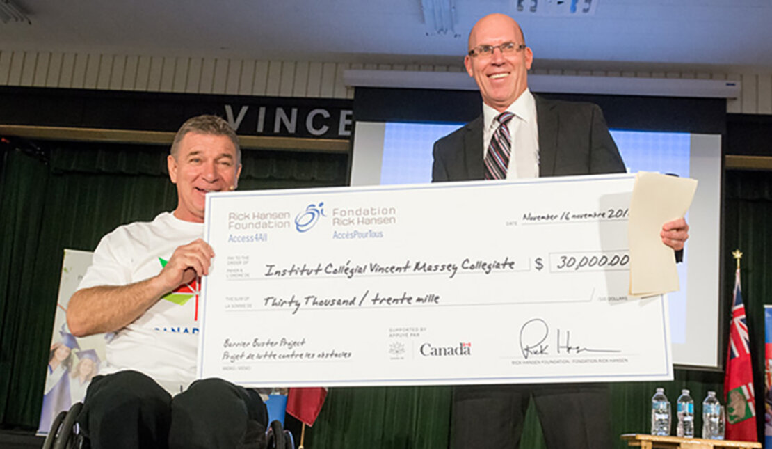 Rick Hansen presents cheque to Vincent Massey Collegiate. 