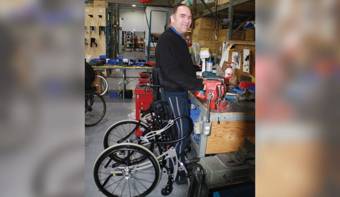 Man with disability standing while working at a workshop