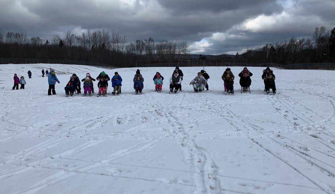 group using sleds in the snow