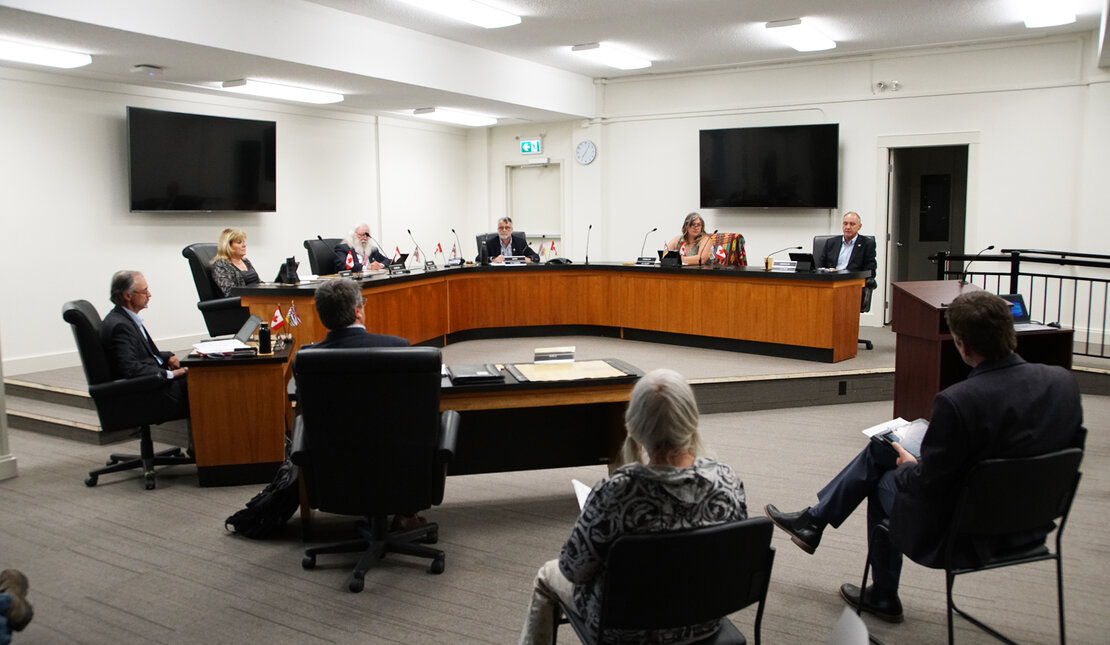 Powell River City Hall Council Chambers with 6 mayor and council members in a meeting, staff and attendees listening.