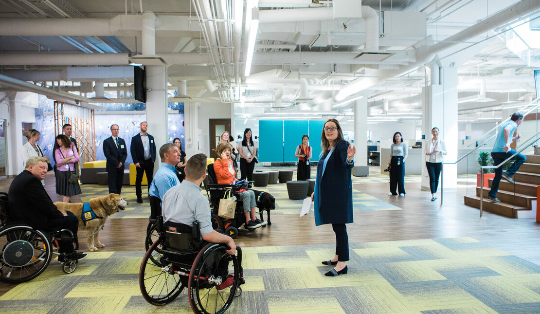 Group of people of different abilities in an accessible common area of a building.