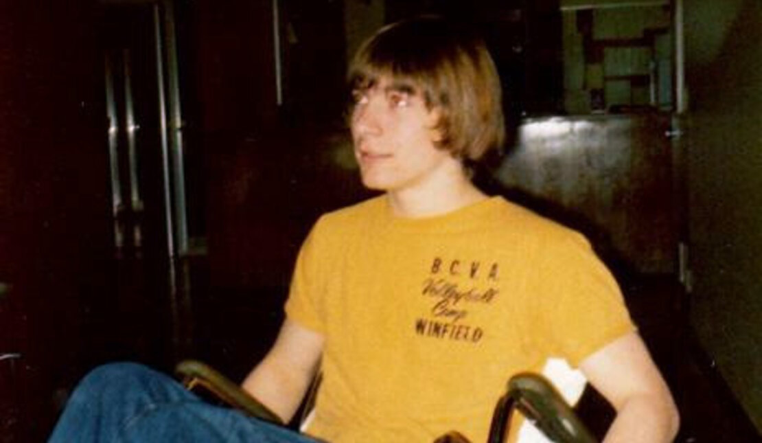 A teenage Rick Hansen popping a wheelie in his wheelchair.