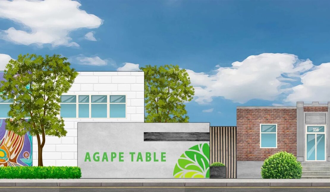 Rendering of three buildings: The small center one has a sign reading ‘Agape Table’. The left building is white with a colorful mural. Trees and a blue sky frame the scene.