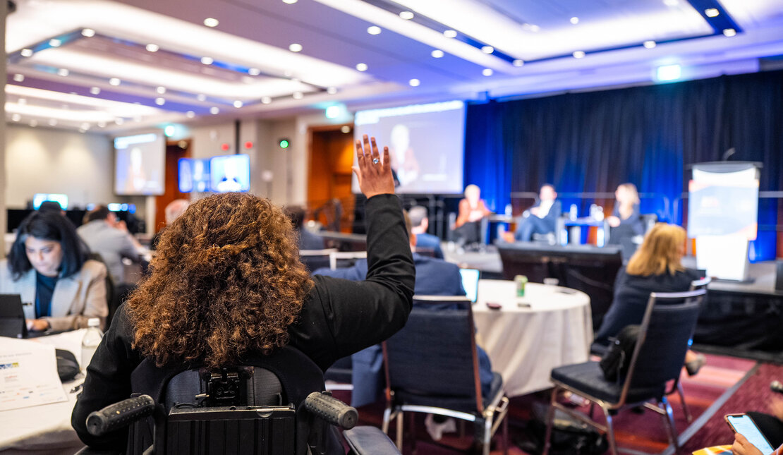 Woman raises her hand during an APN 2026 conference session.