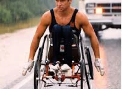 Rick Hansen wheeling through the rain during Man in Motion World Tour