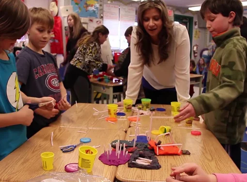 Students gather as they participate in a play-doh activity
