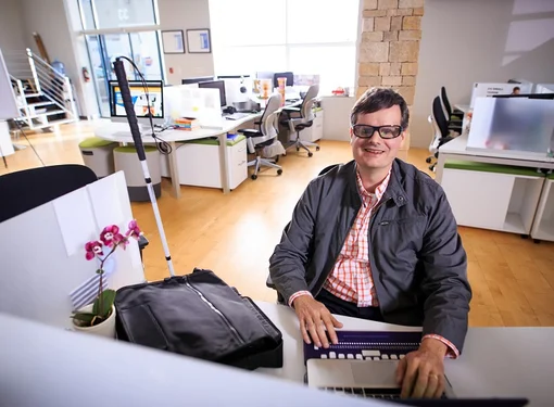 Martin Courcelles at his accessible desk and office space 