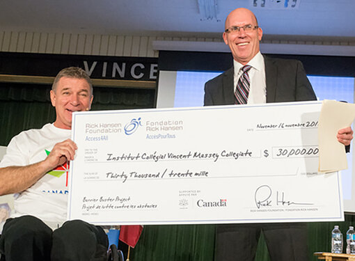 Rick Hansen presents cheque to Vincent Massey Collegiate. 