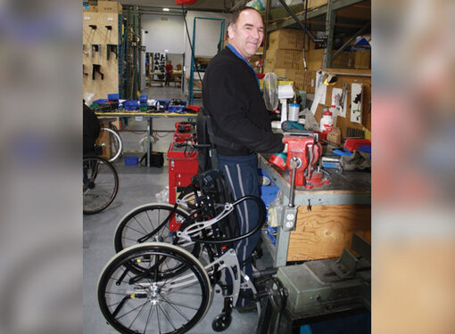 Man with disability standing while working at a workshop