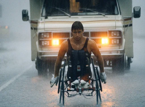 Rick Hansen wheeling through rain during Man in Motion World Tour